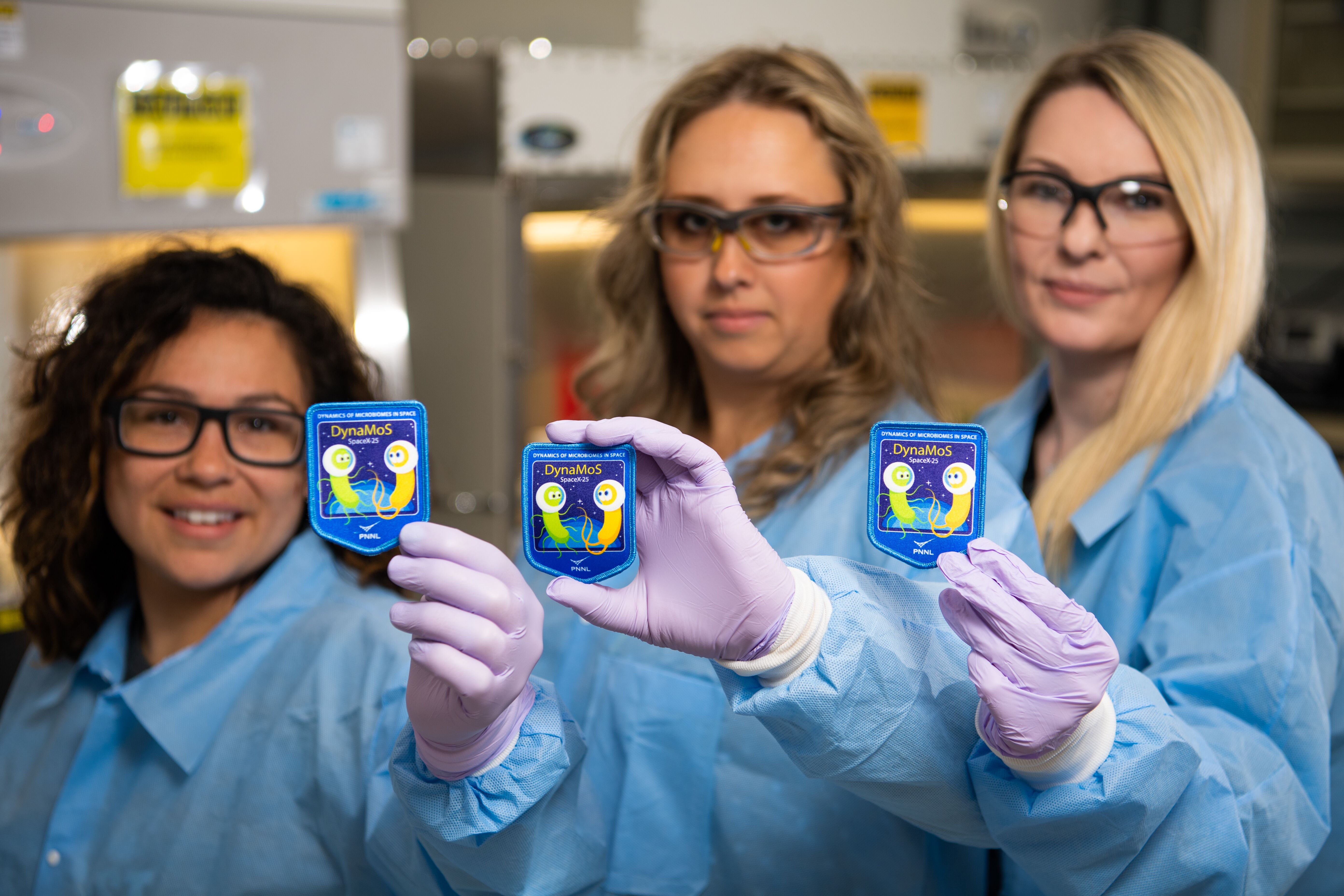 Photo of three researchers holding up patches