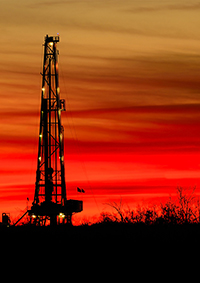 natural gas drill rig at sunset
