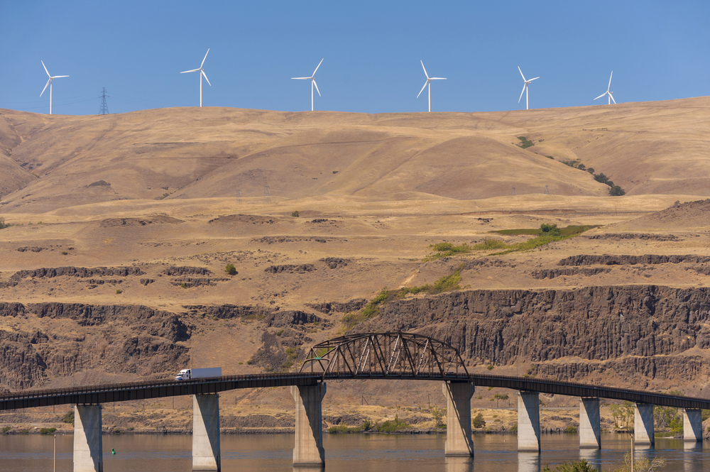 Wind turbines on hill over bridge