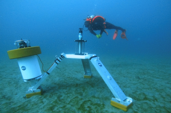 Research diver inspects a hydrophone lander deployed on the seafloor.