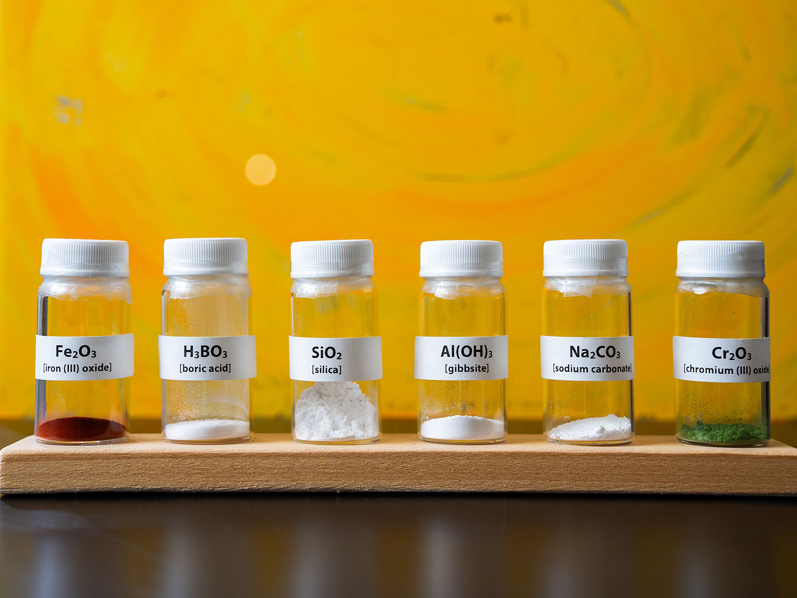 Multiple, clear containers with different chemical compositions inside. 