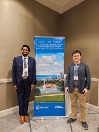 Two people standing next to a poster