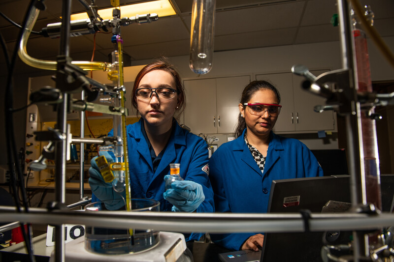 Deepika Mahlotra stands with intern as they conduct research in laboratory