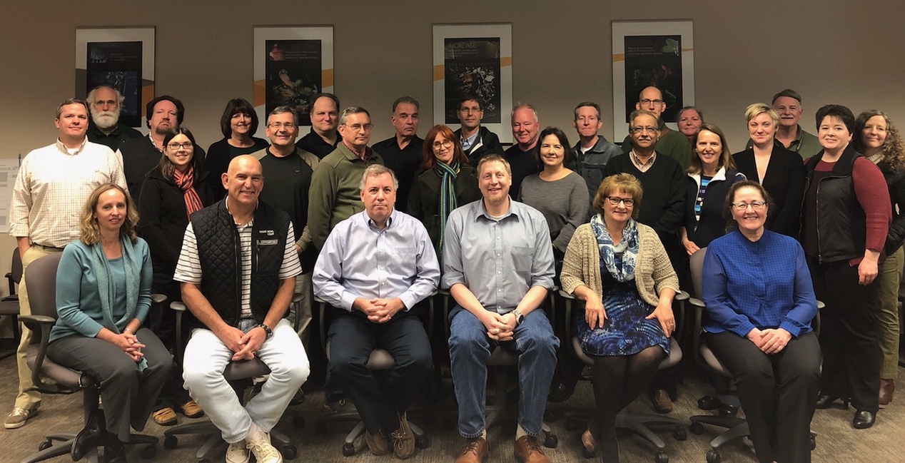 A group of scientists poses for a photo in a meeting room.