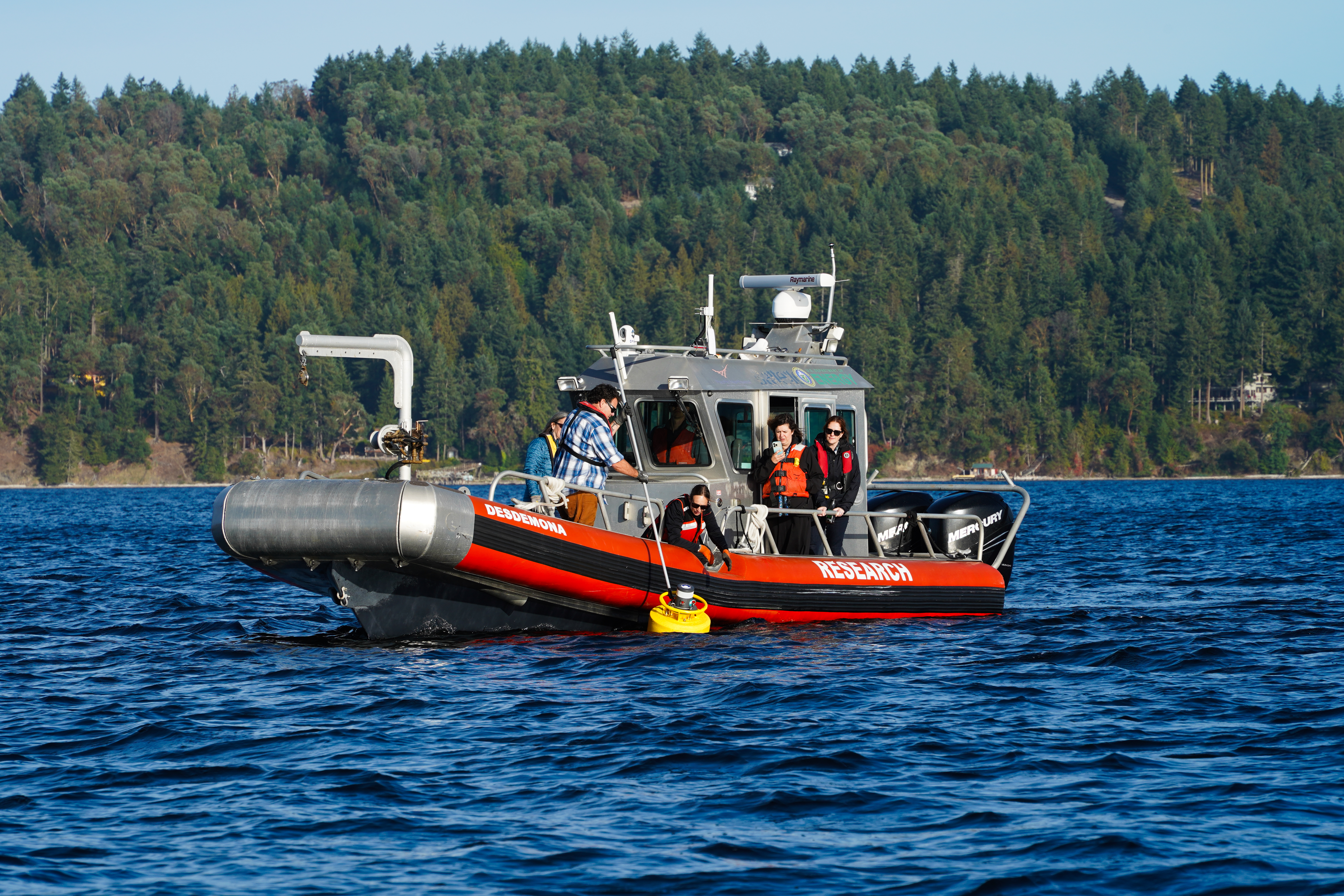 PNNL researchers Joe Haxel and Tristen Myers deploy scientific equipment in the test beds near the PNNL-Sequim campus.