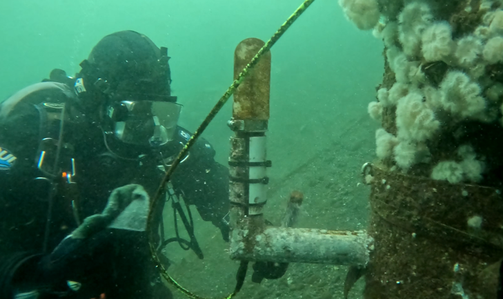 Pier-mounted hydrophone with flow shield during diver inspection. (Photo by Pacific Northwest National Laboratory)