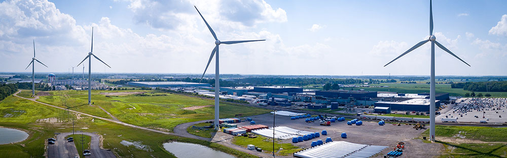 Aerial photo of a stretch of land with several wind turbines.