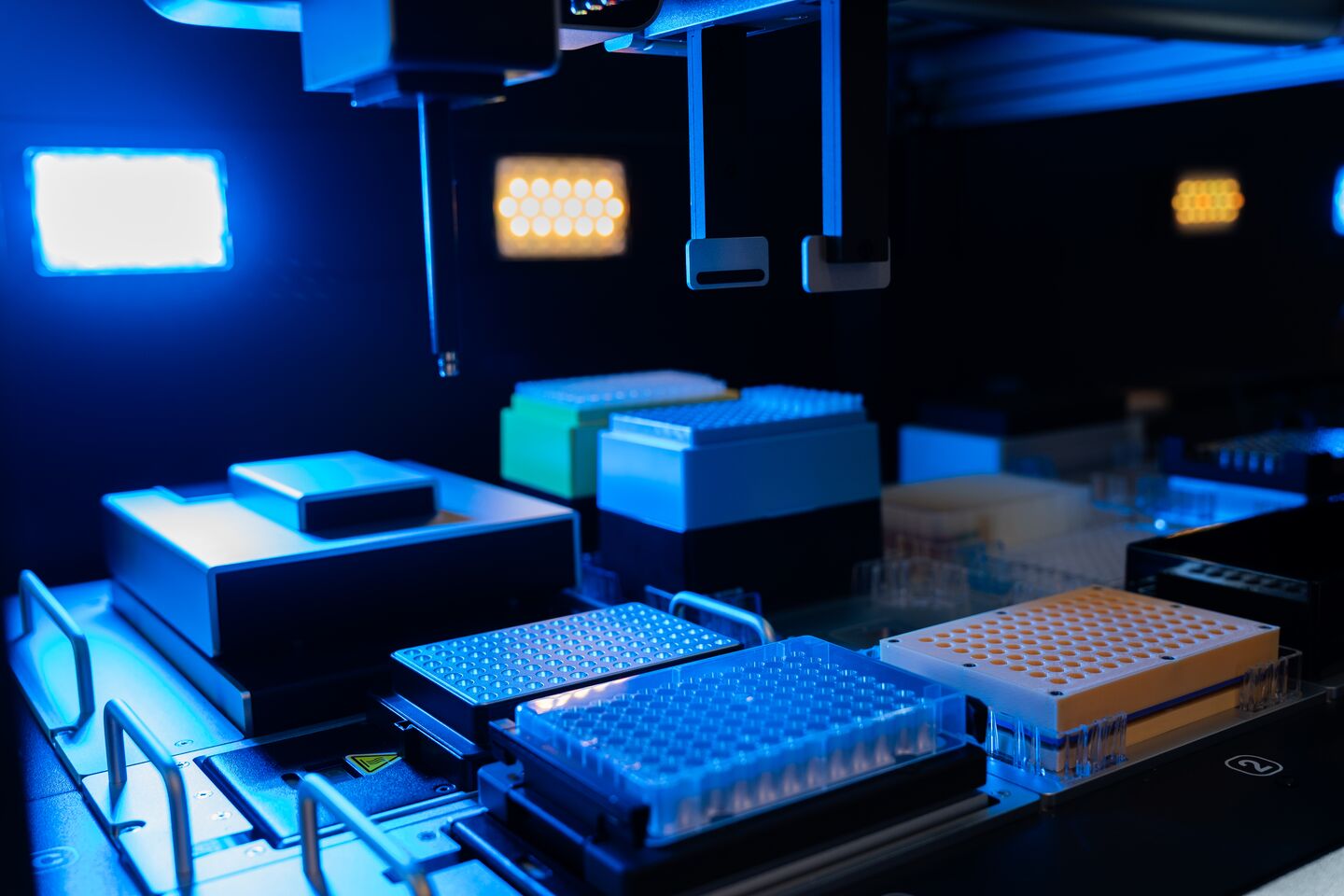 small robotic arms positioned above several trays of test tubes