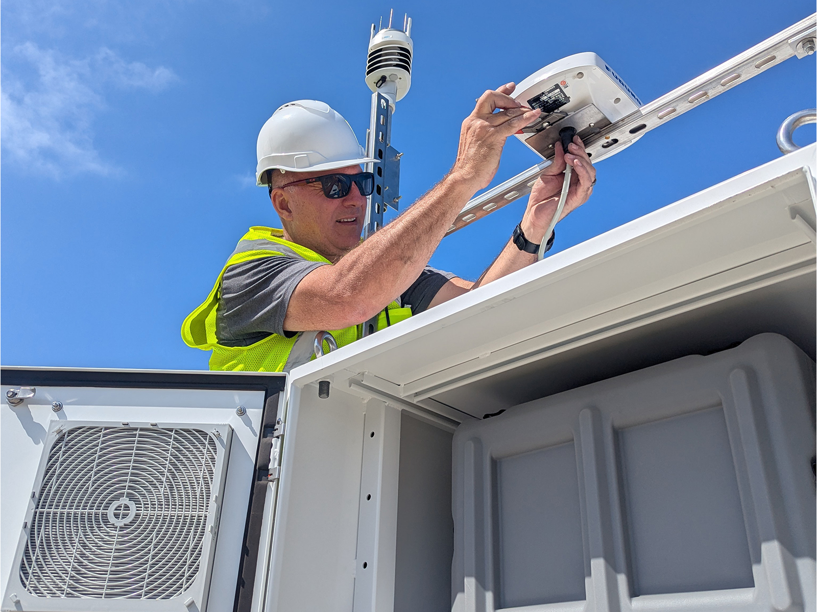 A man checks the power cords of the system.