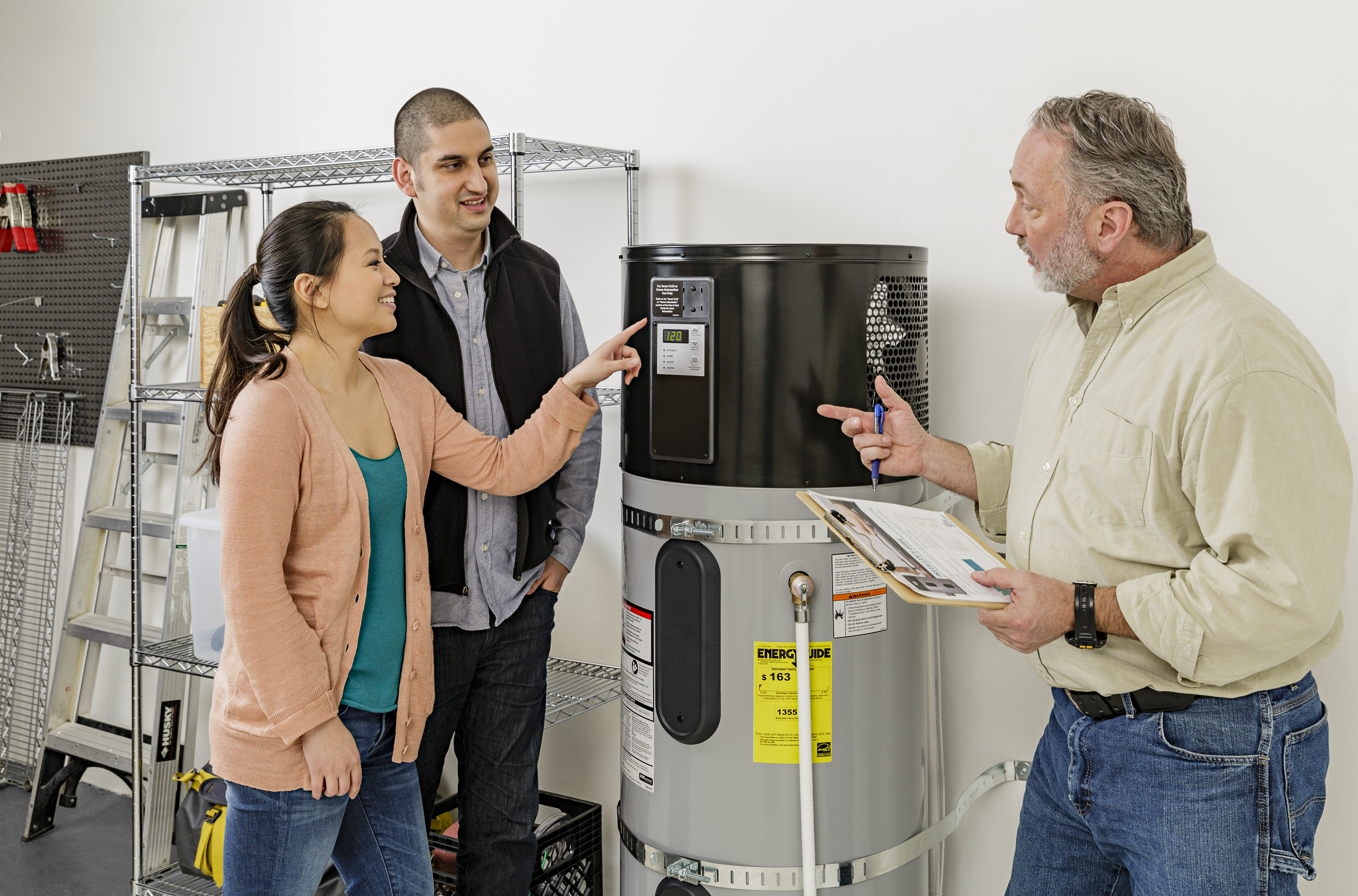 Homeowners discuss their new heat pump water heater with their contractor. (Photo by Hot Water Solutions)