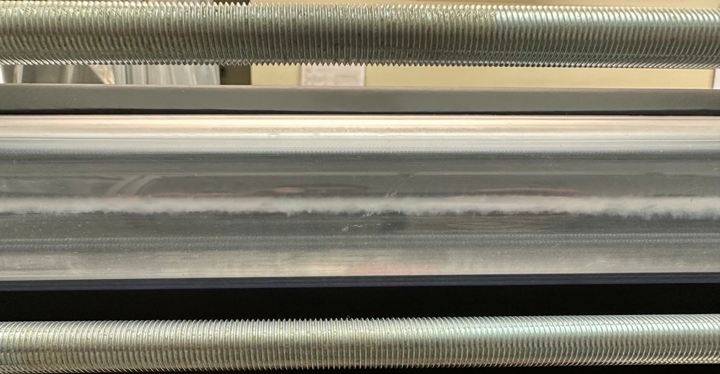 Image shows a close-up shot of two streams of liquid flowing next to each other. In between the streams of liquid, a white substance appears. This is magnesium oxide.