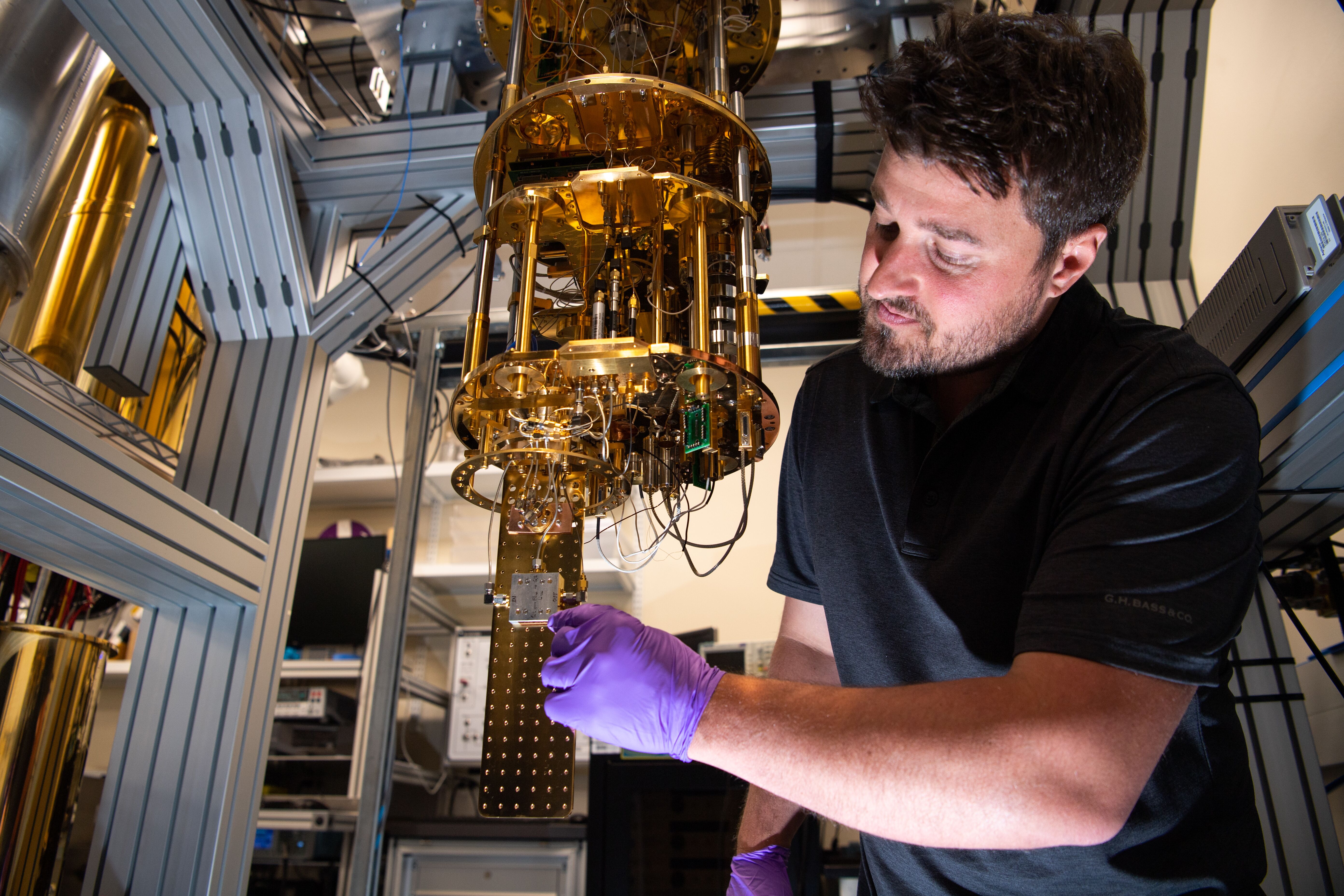 A researcher wearing safety gloves interacting with quantum computing tool.