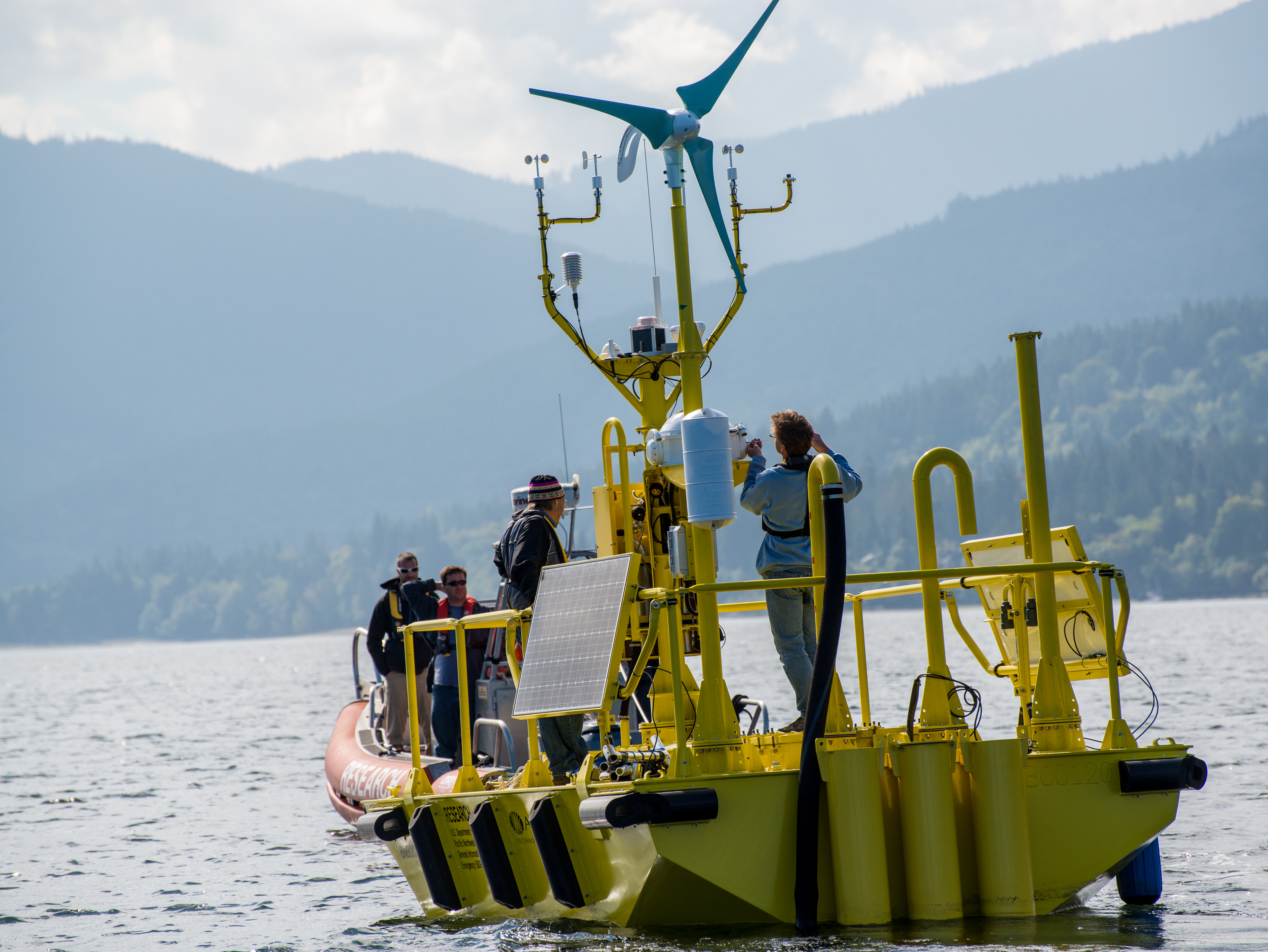 Yellow boat on the water with mountains in the background