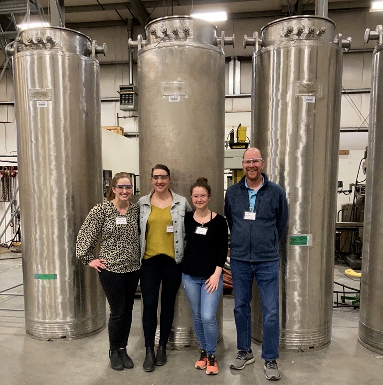 PNNL researchers Emily Campbell, Amy Westesen and Ashley Williams and Reid Peterson stand in front of the columns used within the TSCR system.