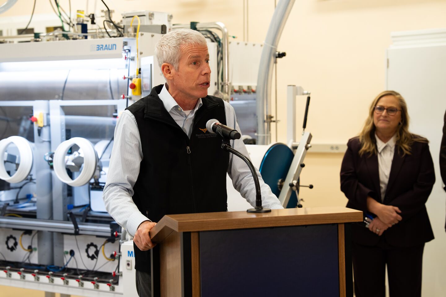 Secretary of Energy Chris Wright stands at a podium with PNNL Lab Director Deb Gracio in the background