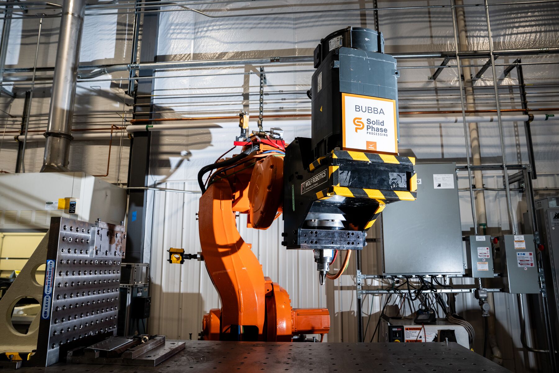 An orange robotic arm, labeled "BUBBA" (a nickname).