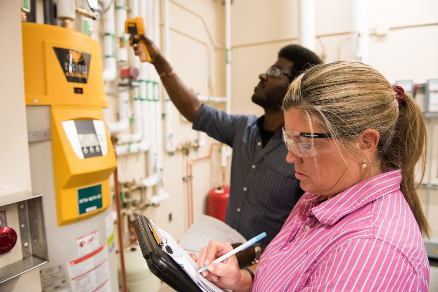 Two people test building control systems.