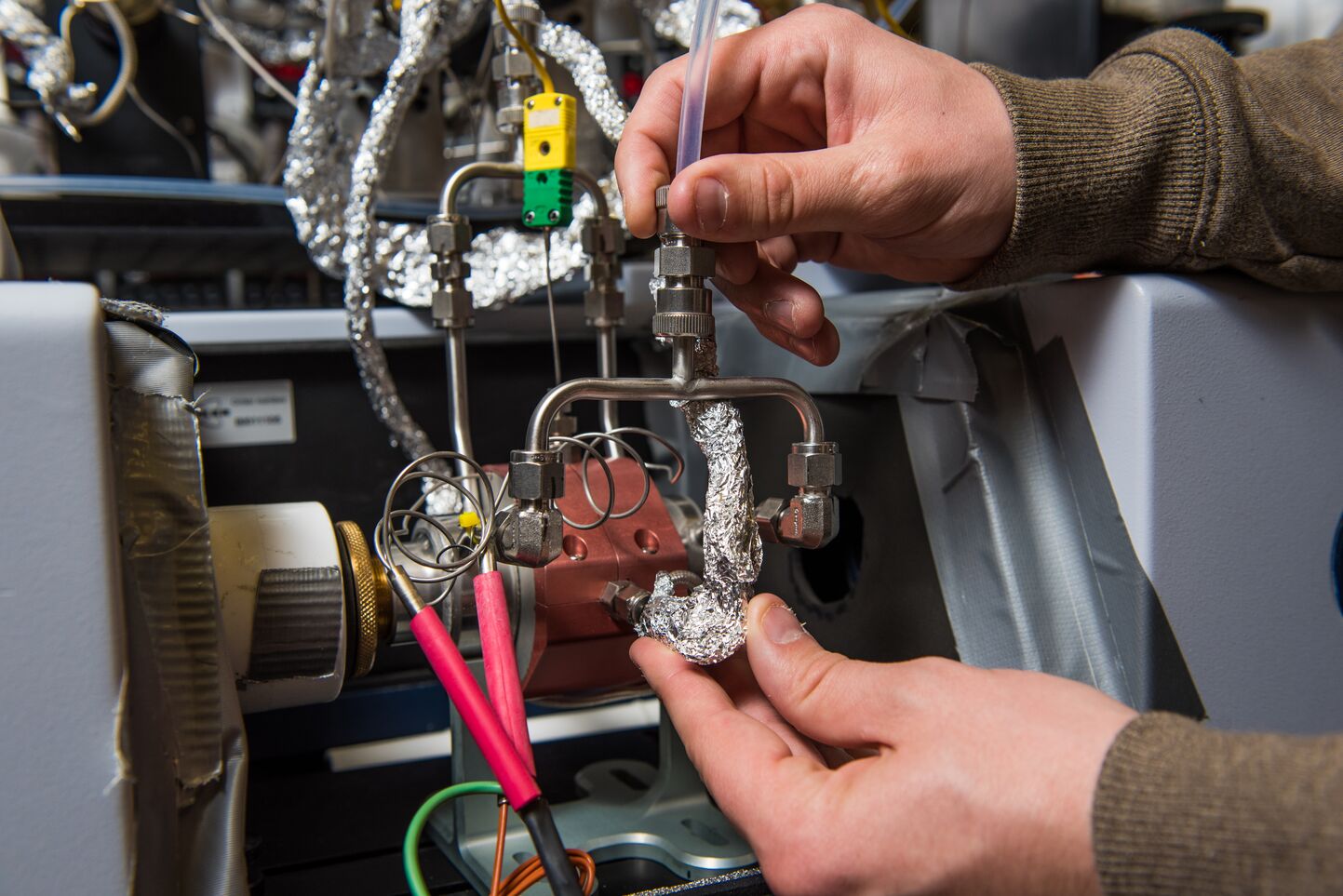 Nicholas Nelson shows off some of the instrumentation he uses to research chemical reactions.