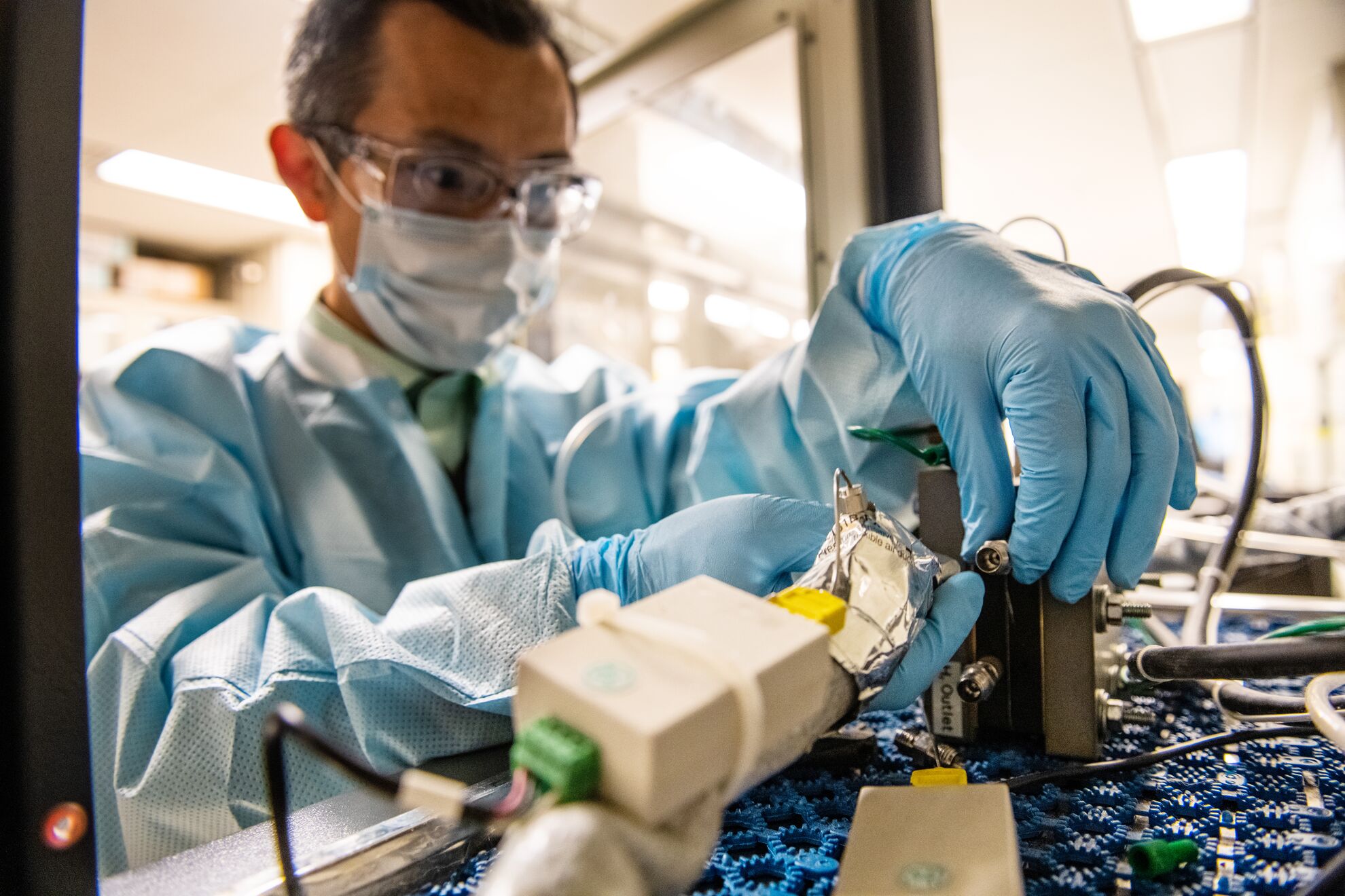 Photo of Yuyan Shao working with a PEM fuel cell