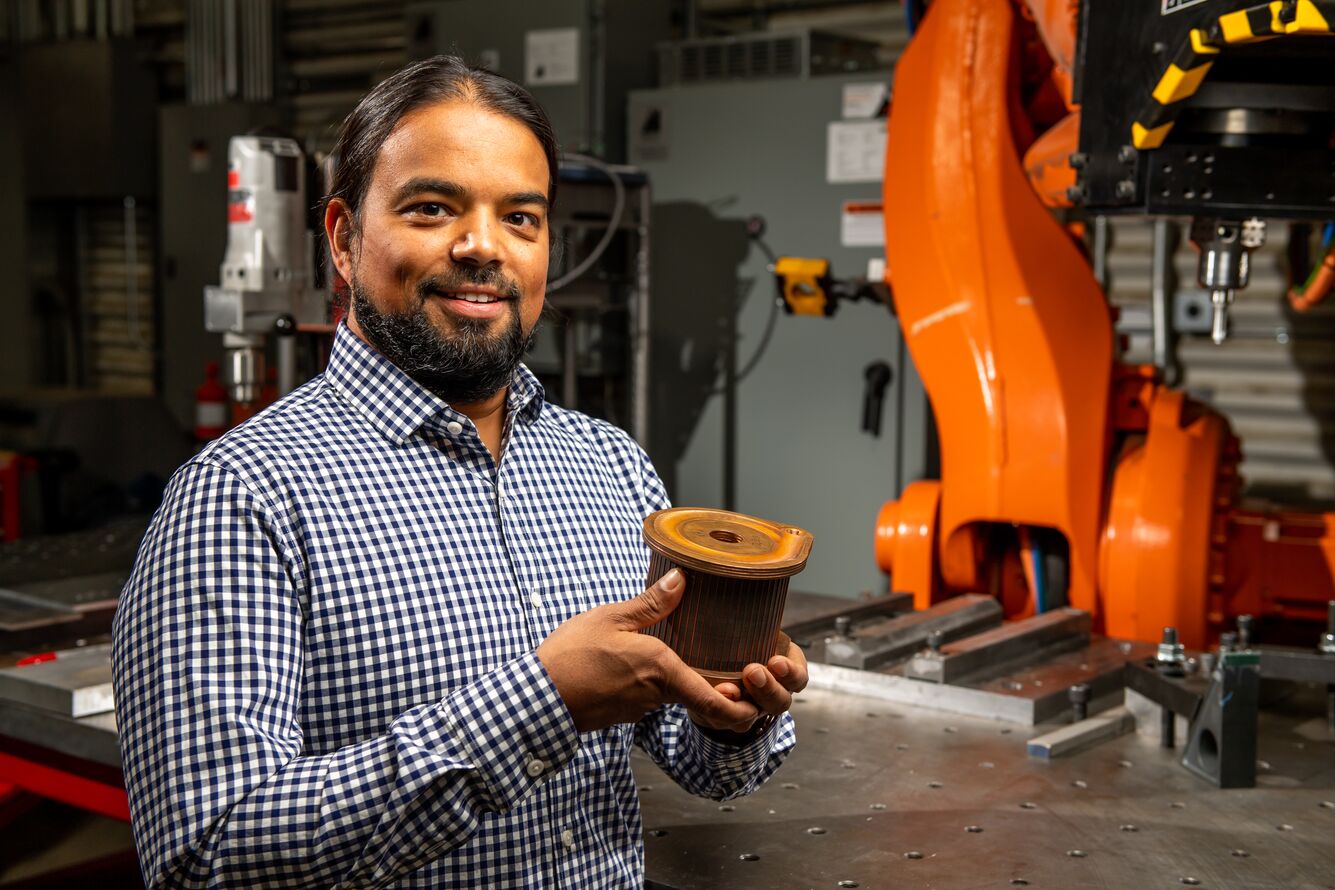 Piyush Upadhyay holds a copper rotor for an electric vehicle induction motor; it was fabricated using friction stir welding.