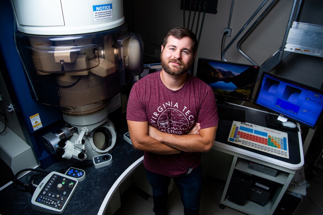 Jacob Haag in laboratory in front of JEOL ARM series transmission electron microscope 