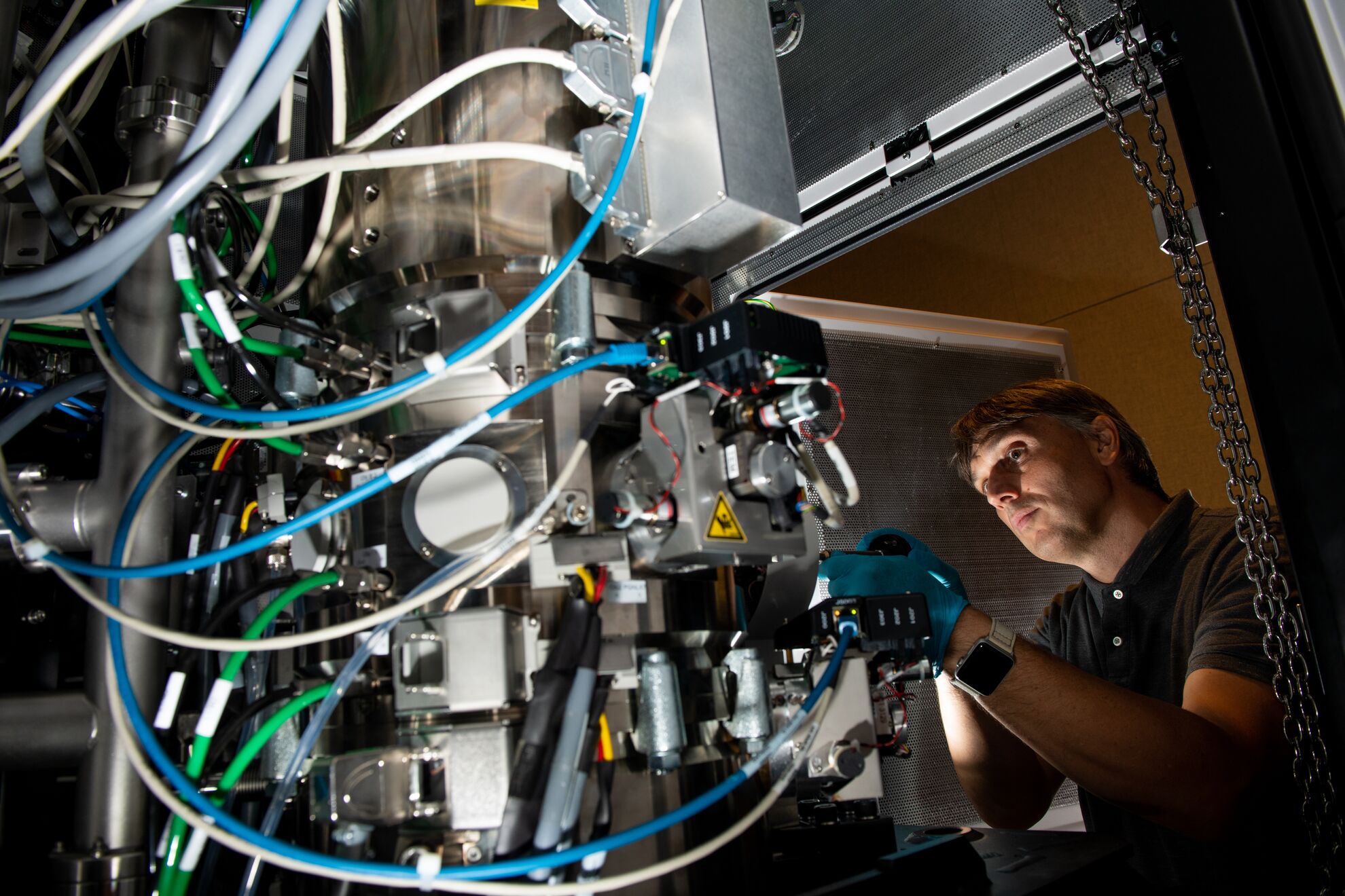 A person operating a large microscope