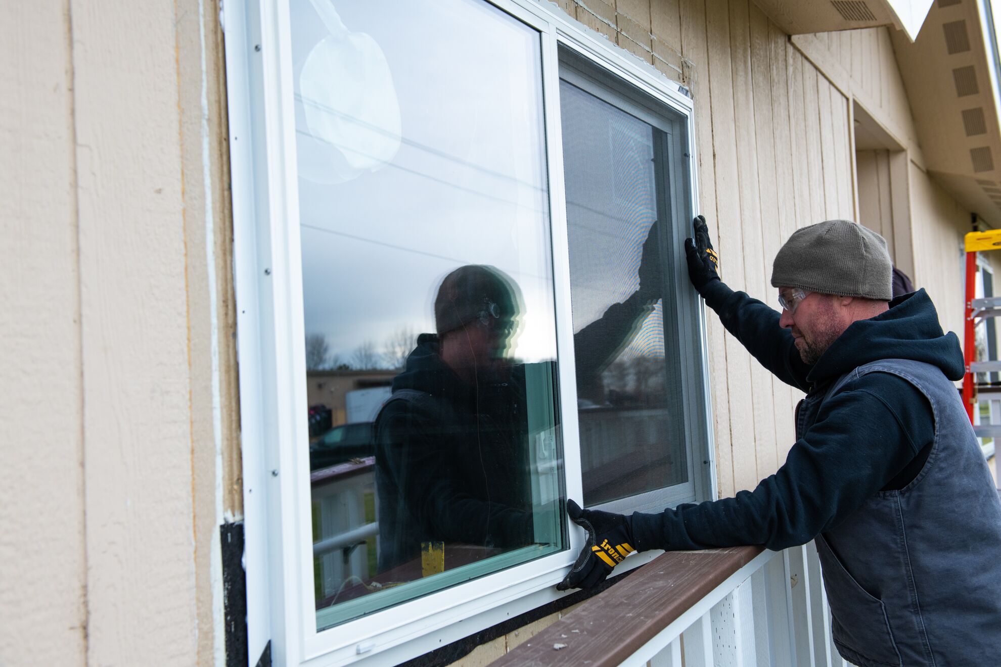A man installs new windows on a home.