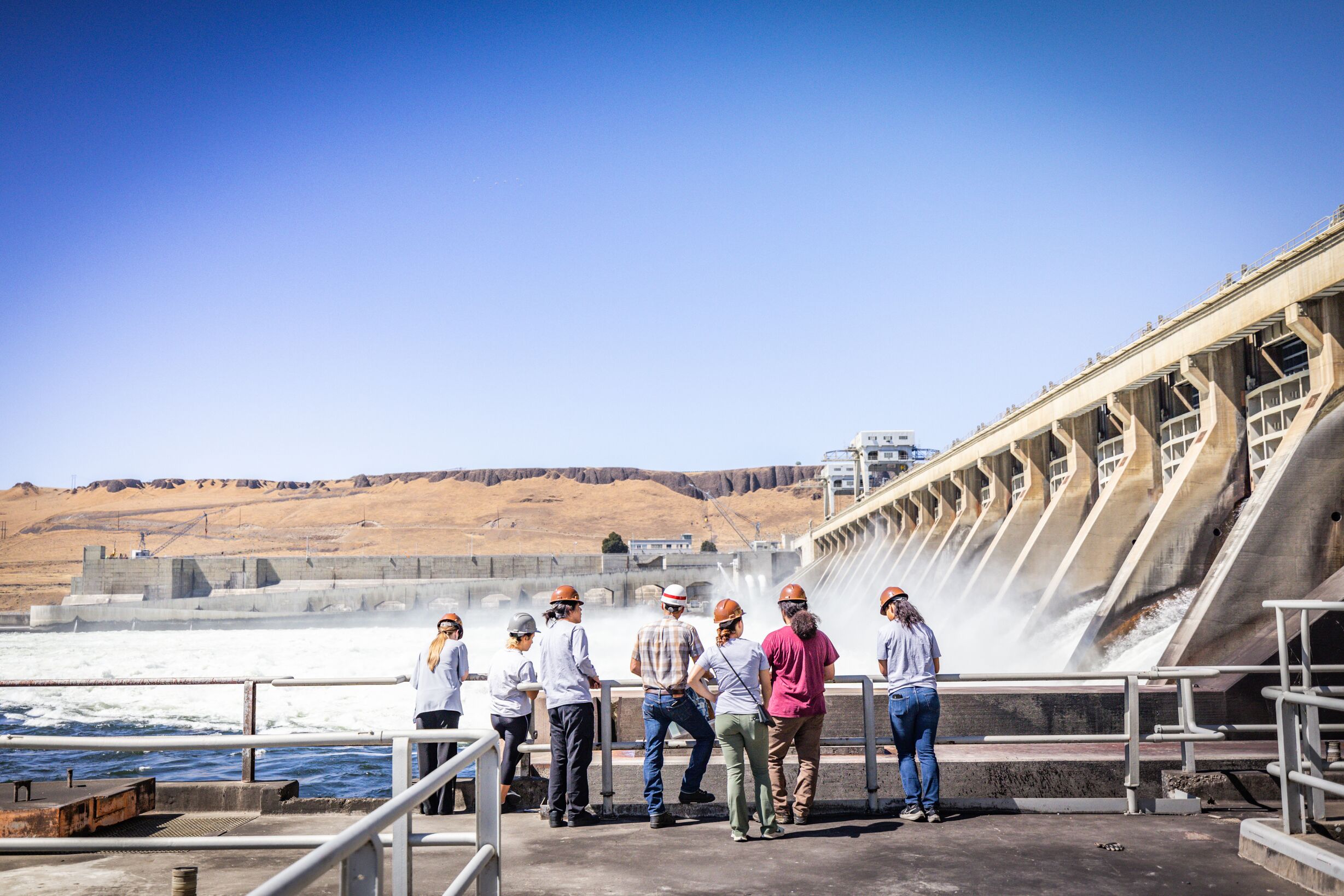 A group of visitors looks at the McNary Dam.
