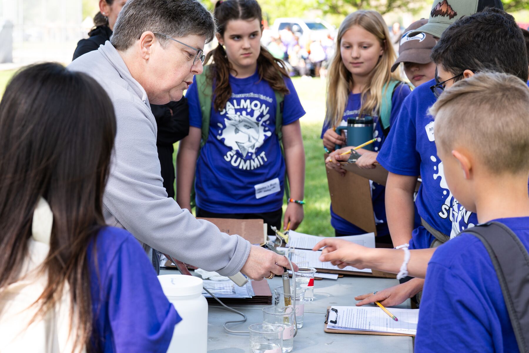STEM Ambassador Amoret Bunn teaches crowd students about water quality at Salmon Summit 2025.