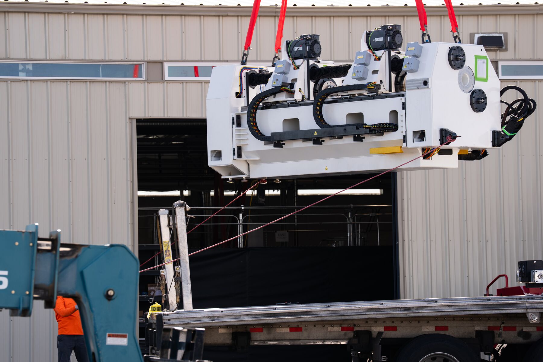 The main portion of the ShAPEshifter system is shown being lifted via crane into the facility where it now operates.
