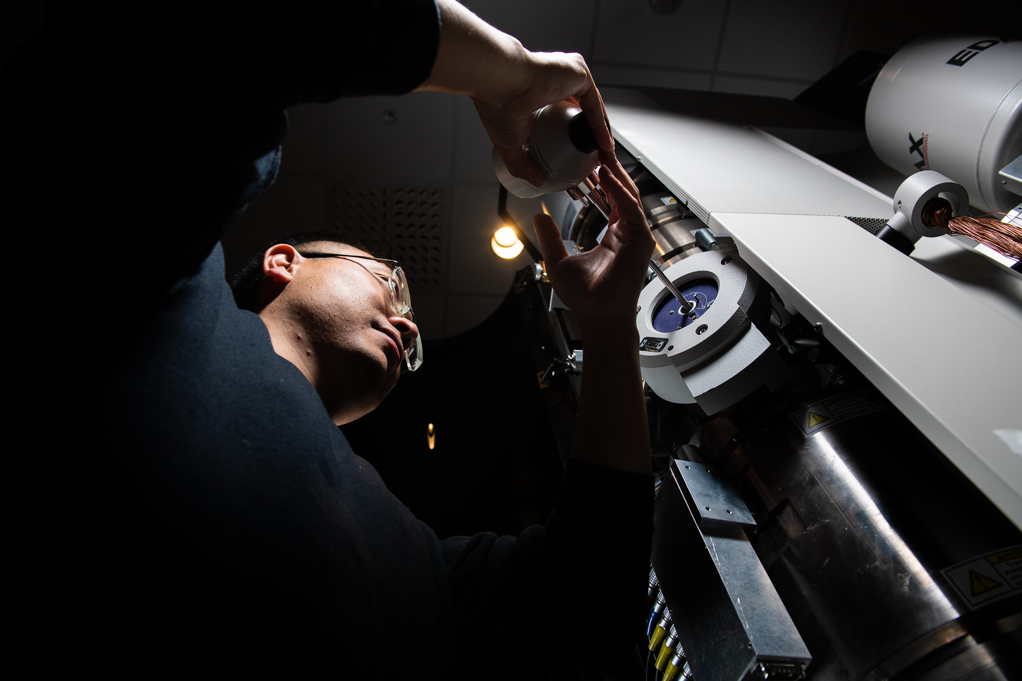 Researcher Yang He adds a sample to the environmental transmission electron microscope