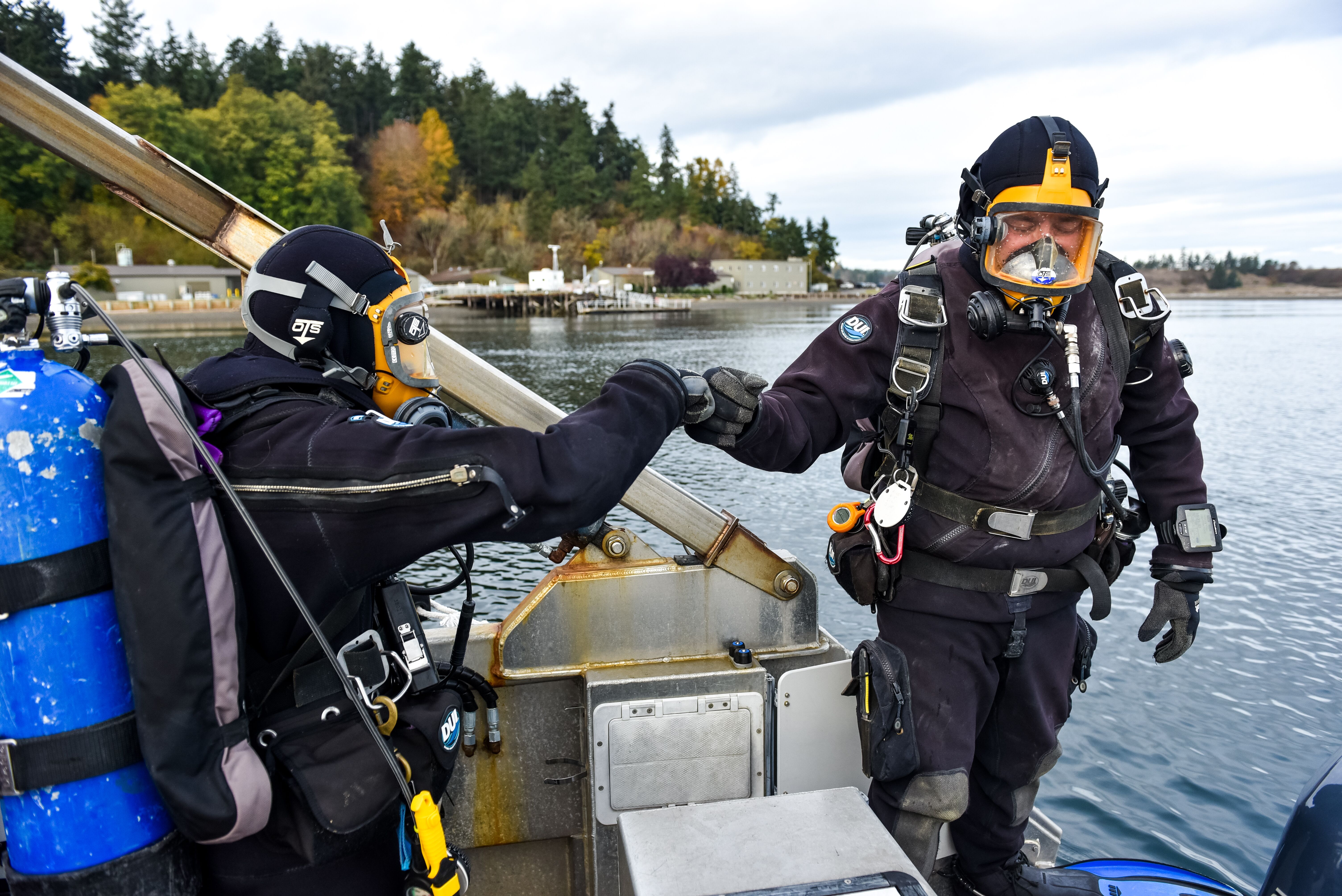 Photo of two researchers wearing scuba gear on a boat