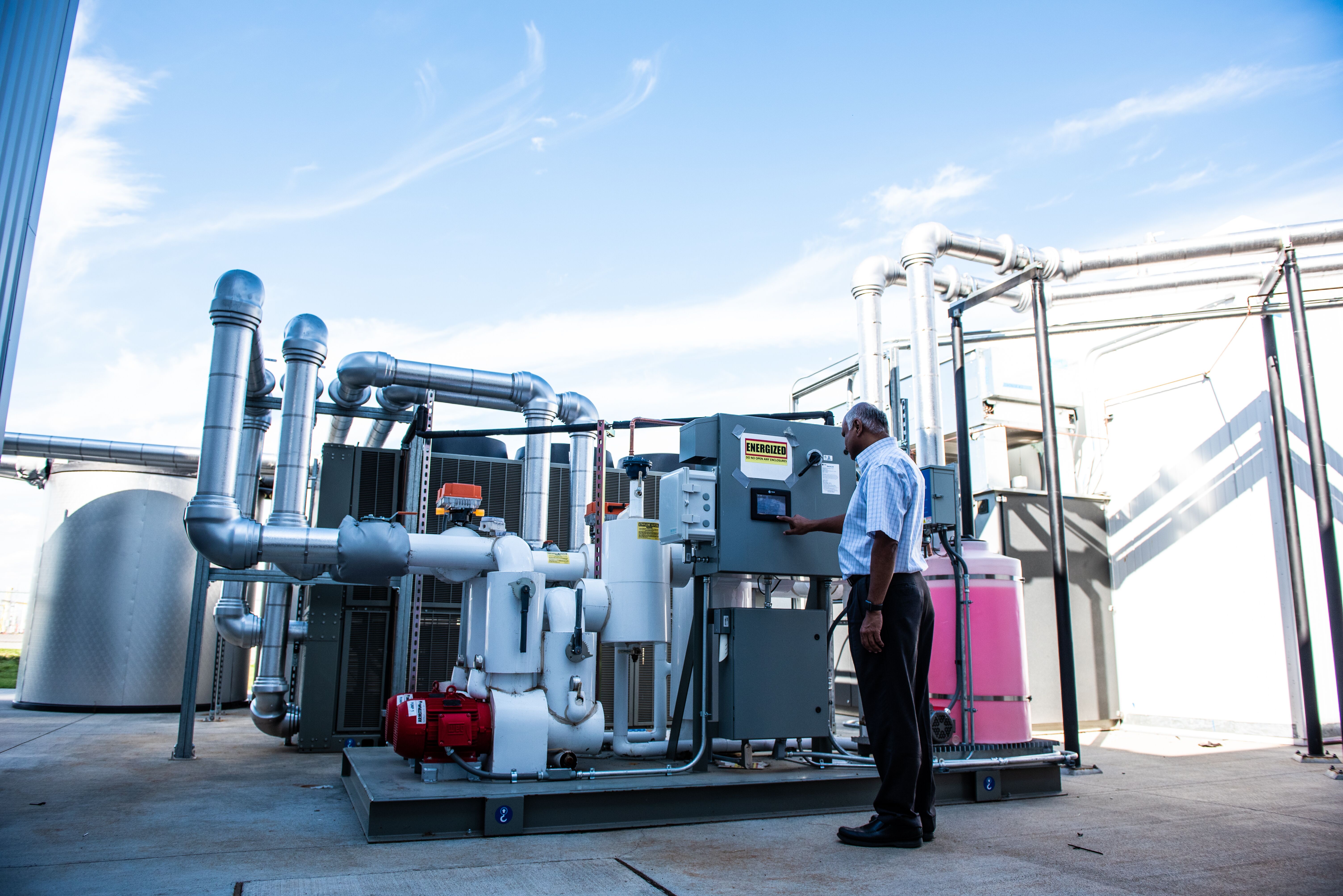 PNNL’s Srinivas Katipamula examines an energy storage system installed at PNNL