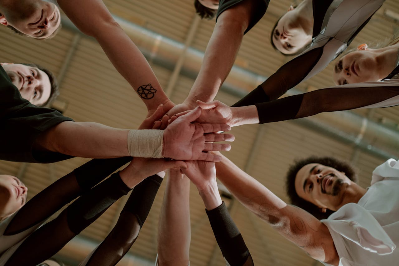 Team of people joining hands for a cheer