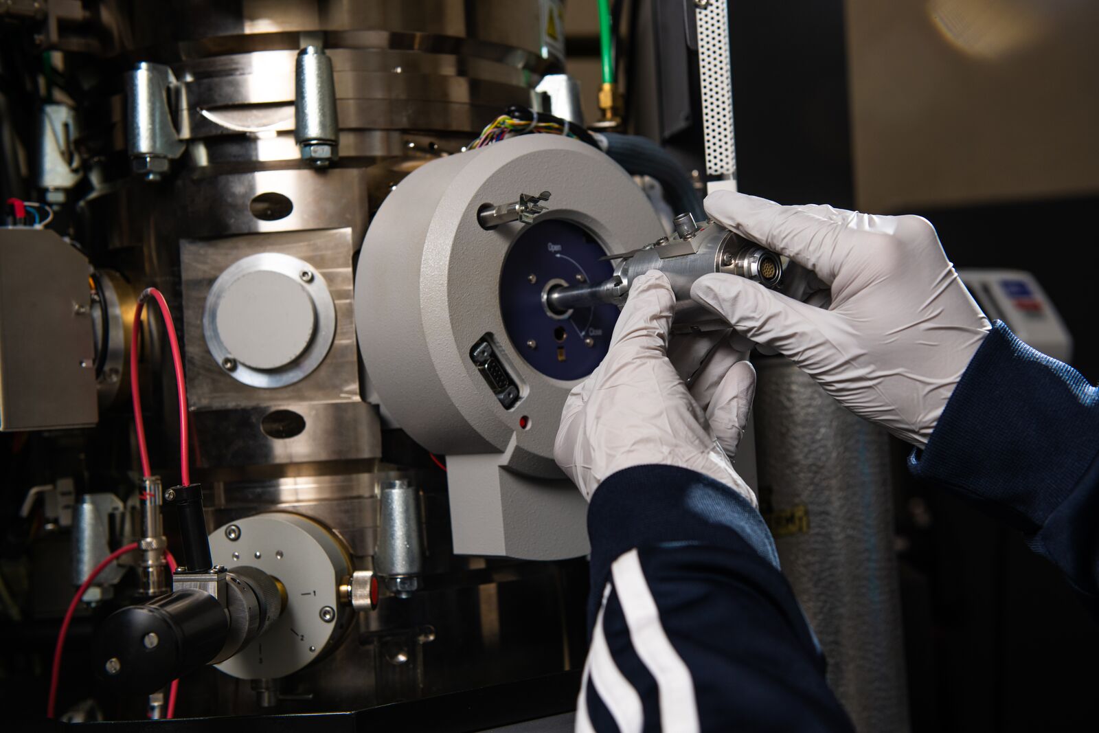 Photo of a researcher inserting a sample into a transmission electron microscope.
