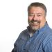 Smiling man with goatee in a blue plaid shirt