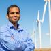 Man standing in front of wind turbines