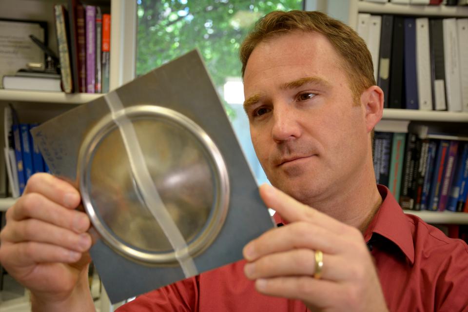 Researcher examining metal component