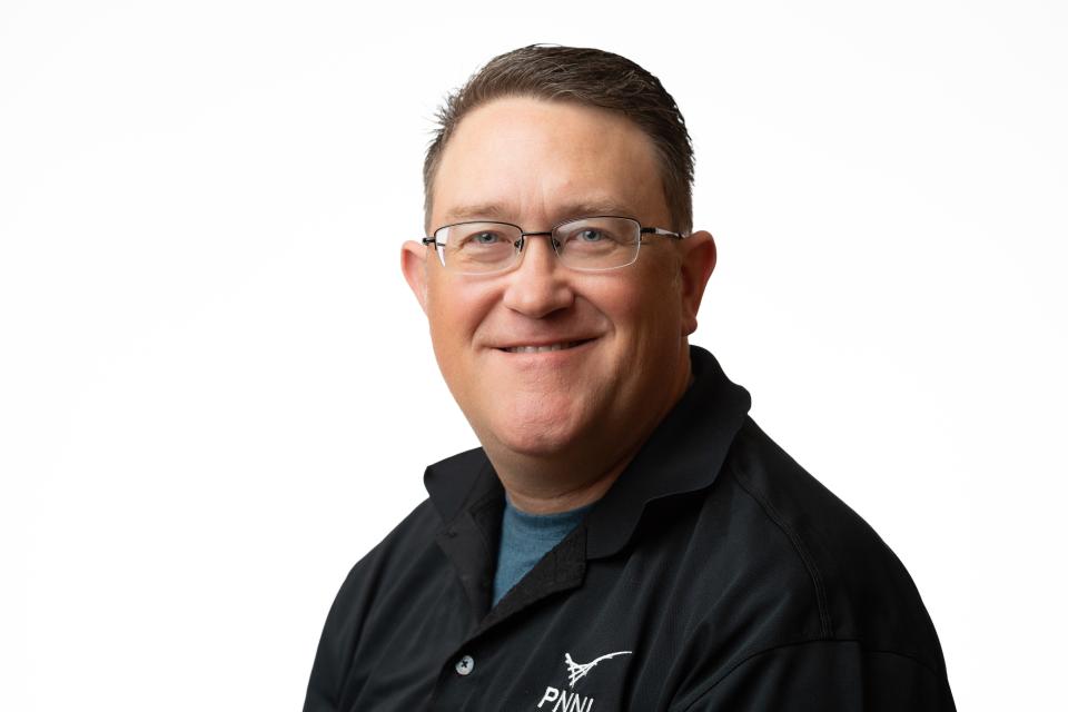 Smiling man wearing glasses and a PNNL branded zip up