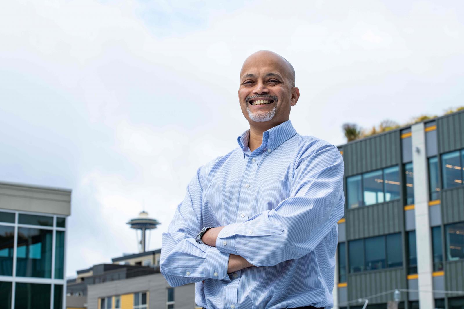 Researcher Tarang Khangaonkar stands outside PNNL's Seattle Research Center with the Space Needle in the background.