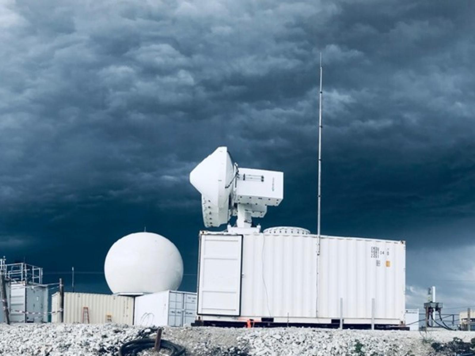 Photograph of scientific equipment surrounded by a dark, cloudy sky