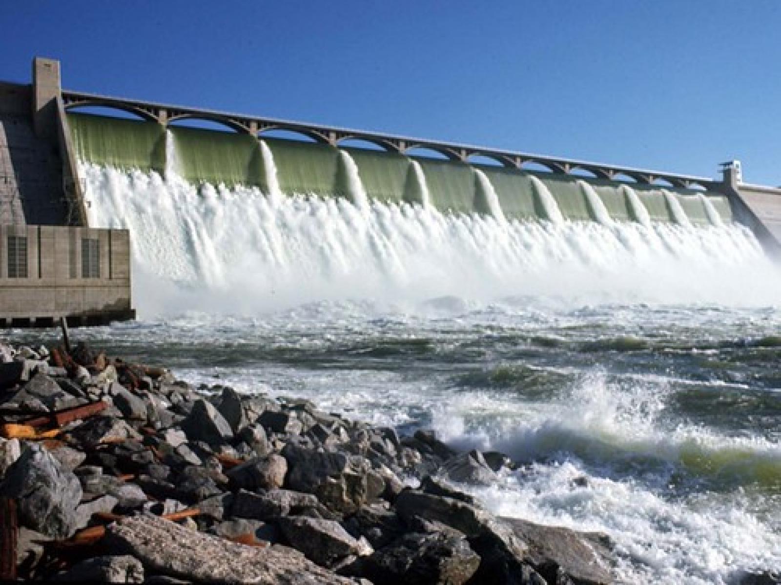 water spilling over a long concrete dam