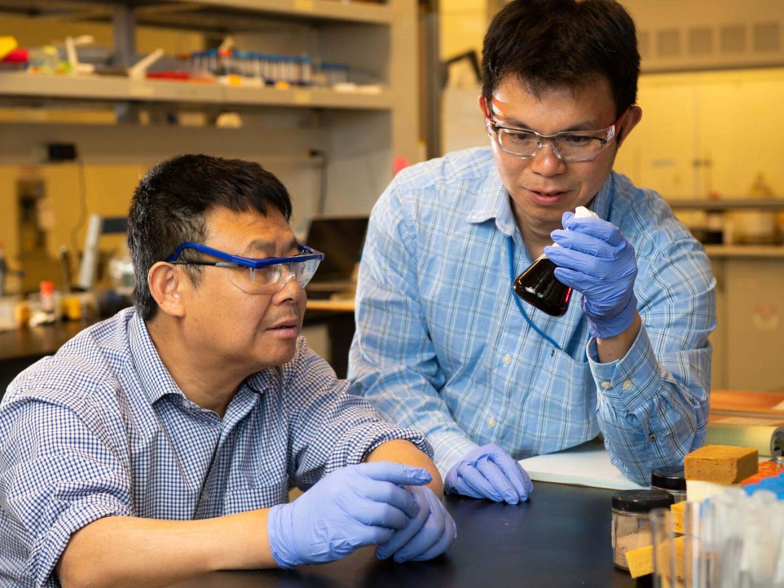 Two scientists examine lignin products in the lab