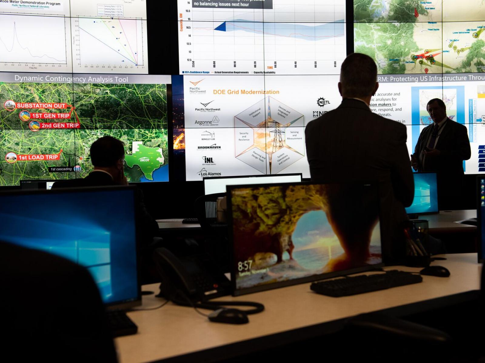 Researchers discuss the power grid in an electrical control room