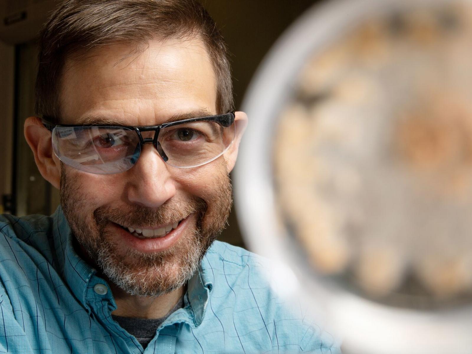 photo of PNNL researcher Scott Baker who is wearing glasses and is near a fungi sample.