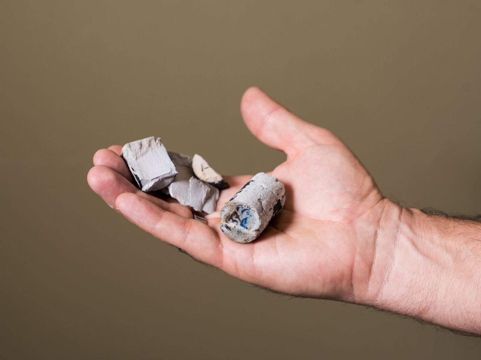 A hand holding blocks of cement
