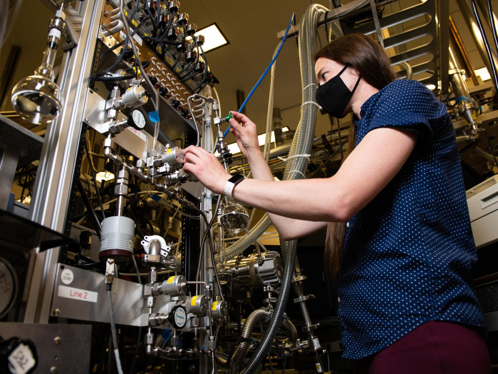 Photo of PNNL researcher Loni Kringle adjusting water dosing lines.