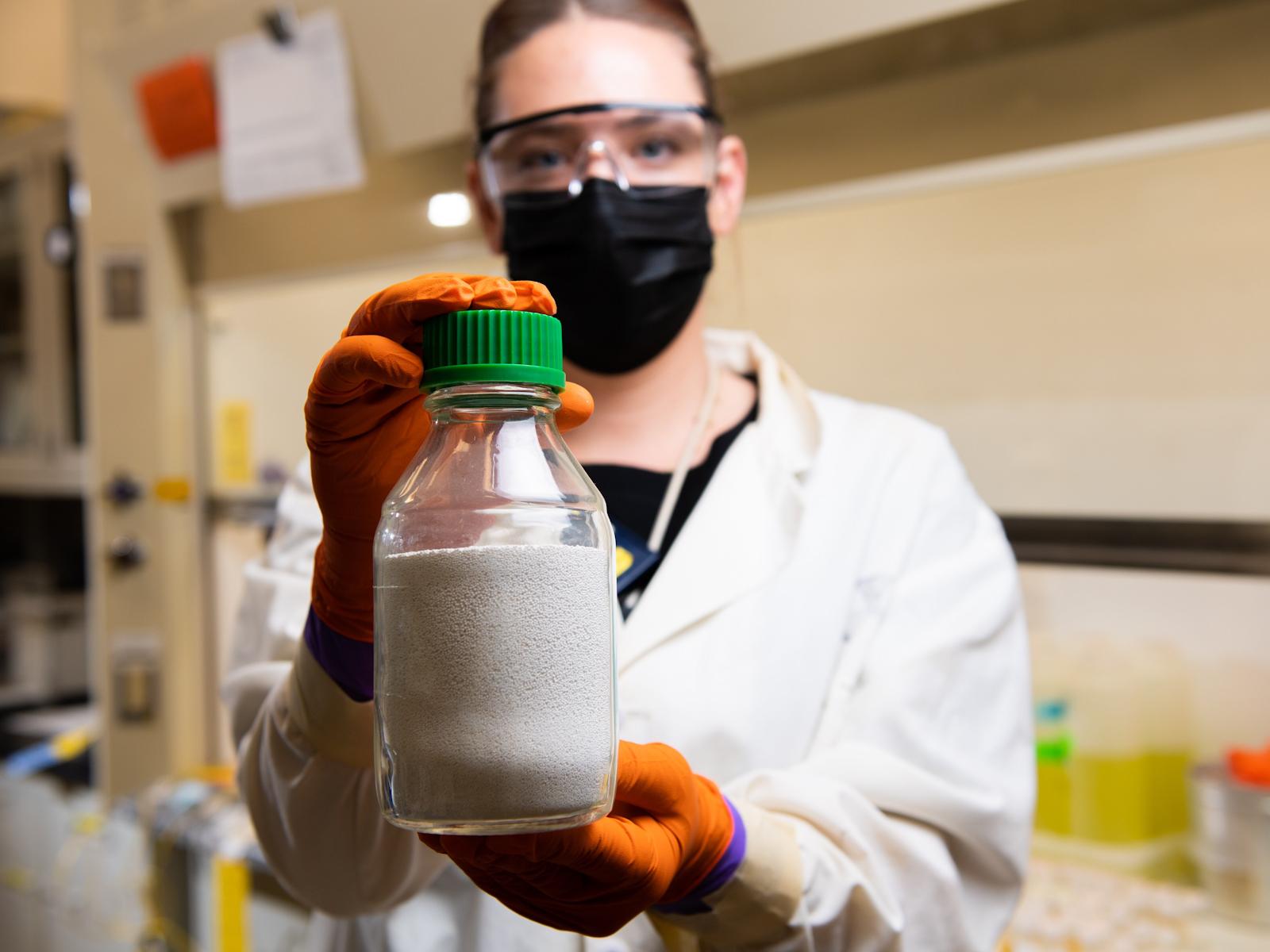 PNNL researcher Amy Westesen holds ion exchange media crystalline silicotitanate, used in the TSCR system to capture cesium. 