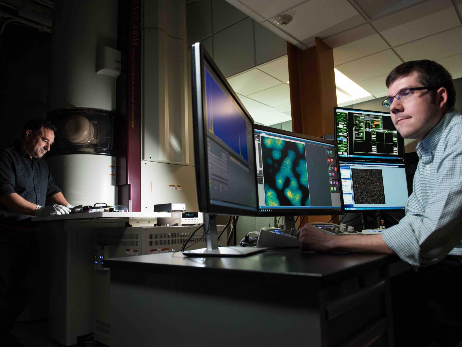 Scientists using a large piece of research equipment.