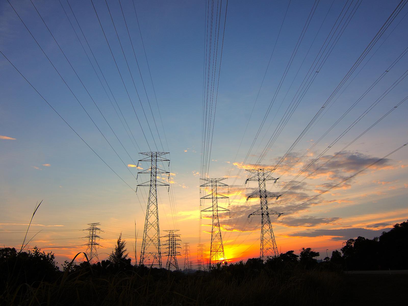 Photograph of power lines in front of a sunset